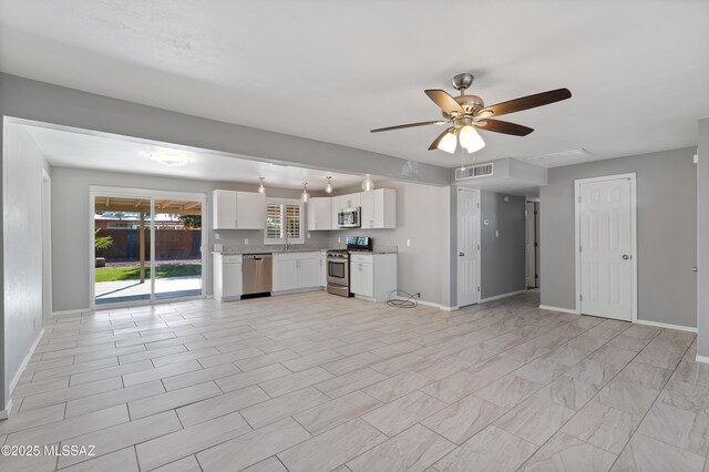 kitchen with stainless steel appliances, white cabinetry, and ceiling fan