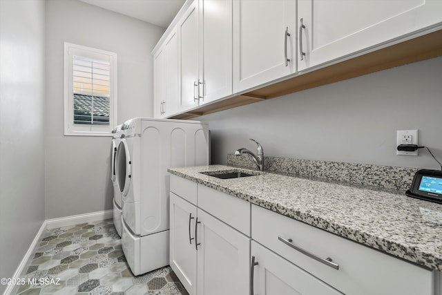 laundry room featuring washing machine and dryer, sink, and cabinets