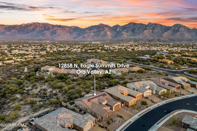 aerial view at dusk featuring a mountain view