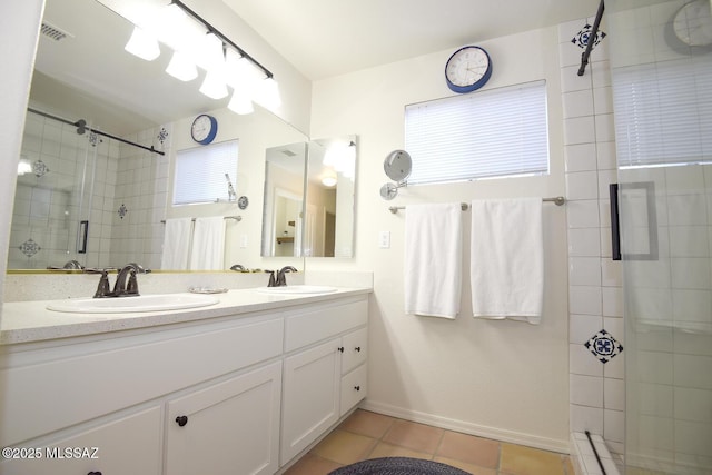 bathroom featuring tile patterned flooring, vanity, and walk in shower