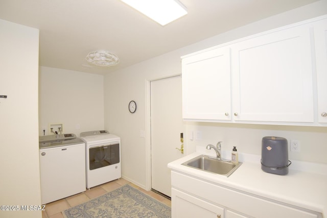 laundry area featuring cabinets, light tile patterned floors, washer and clothes dryer, and sink