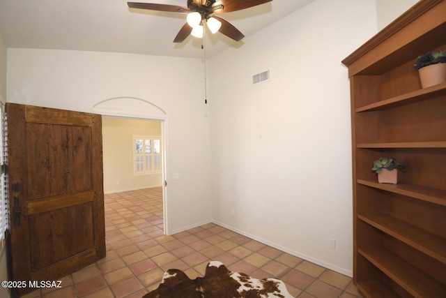 tiled spare room featuring ceiling fan