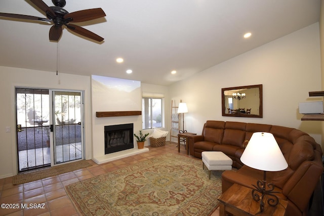 living room featuring ceiling fan, a fireplace, light tile patterned floors, and vaulted ceiling