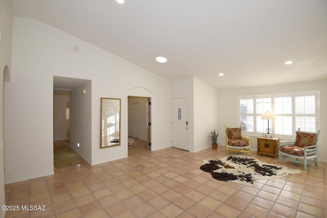 unfurnished room featuring light tile patterned flooring and lofted ceiling