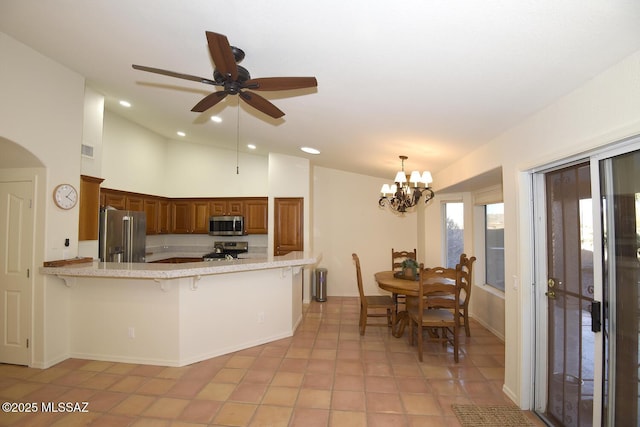 kitchen featuring stainless steel appliances, kitchen peninsula, a breakfast bar area, light tile patterned flooring, and ceiling fan with notable chandelier