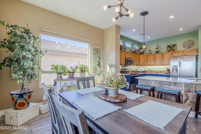 dining space with an inviting chandelier and light hardwood / wood-style floors