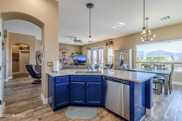 kitchen featuring ceiling fan with notable chandelier, dishwasher, blue cabinetry, hanging light fixtures, and sink