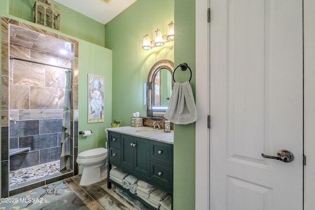 bathroom featuring a shower, wood-type flooring, toilet, and vanity