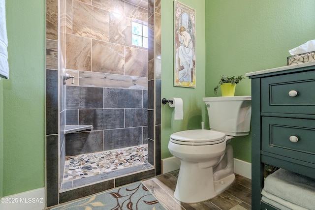 bathroom featuring toilet and a tile shower