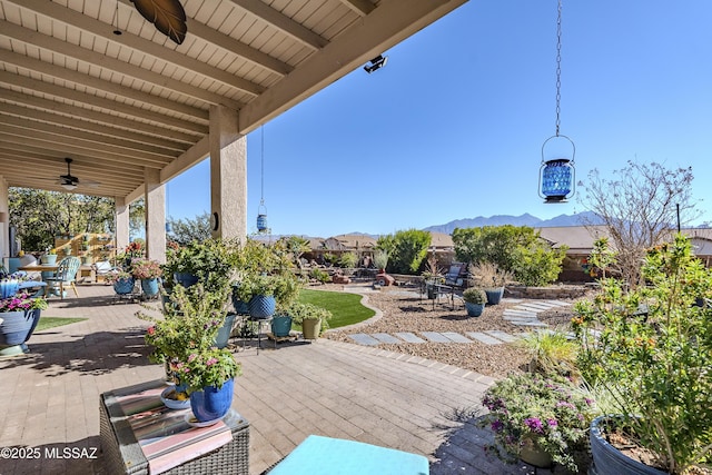 view of patio with ceiling fan and a mountain view