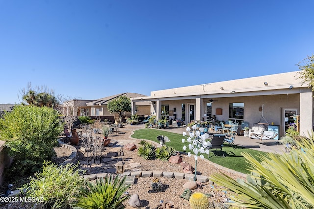 rear view of house with ceiling fan and a patio