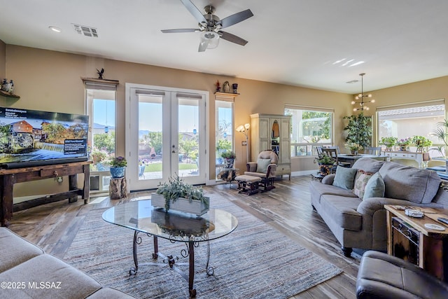 living room with light wood-type flooring, ceiling fan, and plenty of natural light