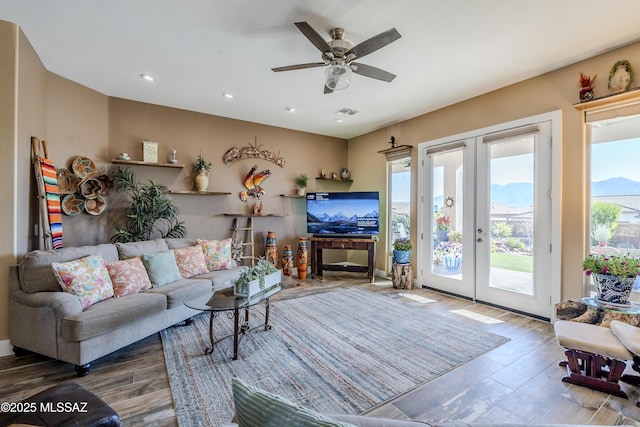 living room with hardwood / wood-style flooring, ceiling fan, and french doors