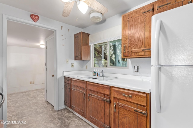 kitchen featuring ceiling fan, sink, and white refrigerator