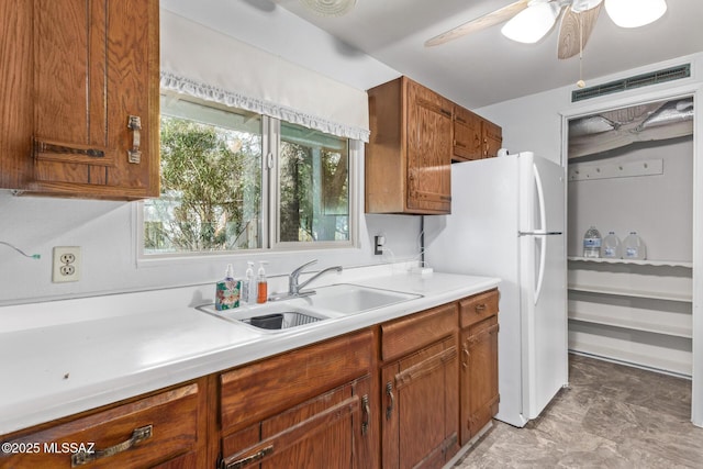 kitchen with ceiling fan, white fridge, and sink