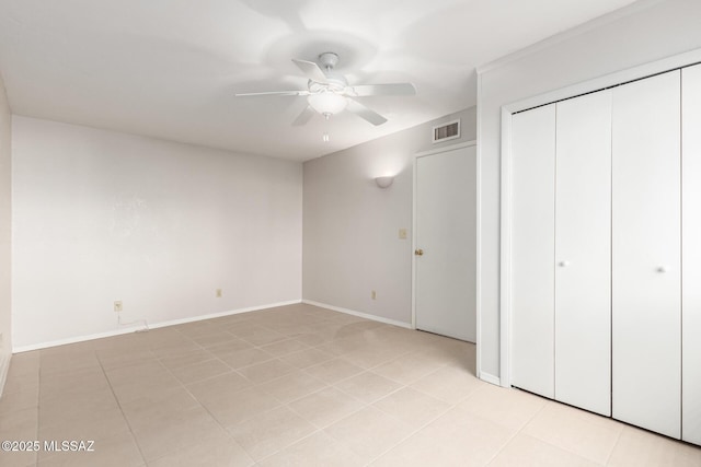 unfurnished bedroom with light tile patterned floors, a closet, and ceiling fan