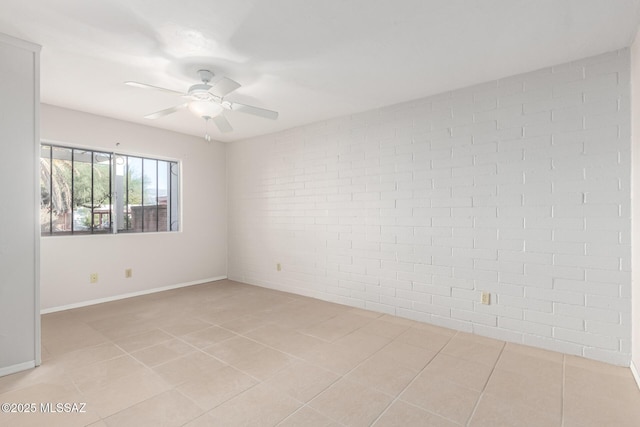 spare room with light tile patterned flooring, ceiling fan, and brick wall