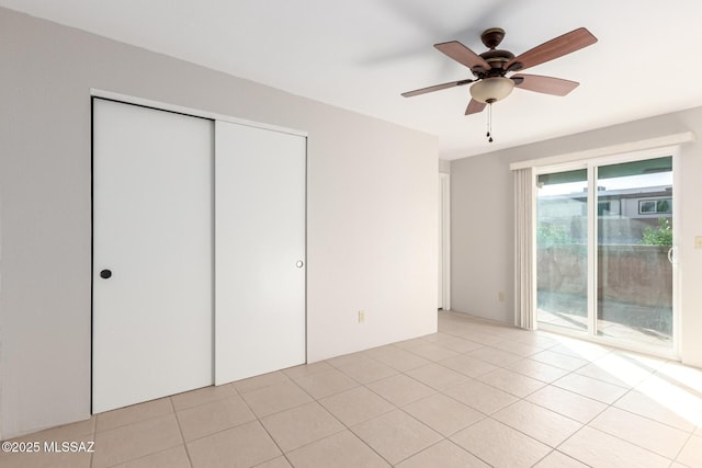 unfurnished bedroom featuring light tile patterned floors, access to outside, a closet, and ceiling fan