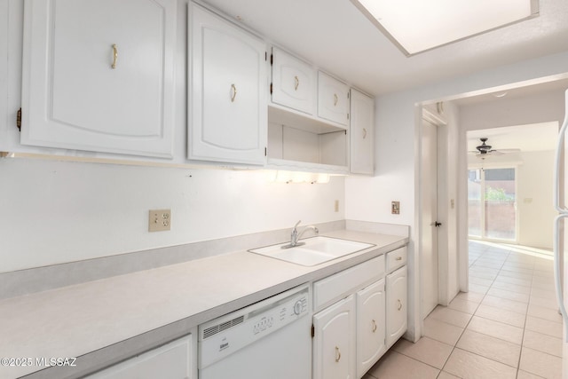 kitchen featuring white dishwasher, sink, light tile patterned floors, and white cabinets