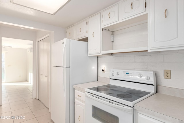 kitchen featuring light tile patterned flooring, white appliances, decorative backsplash, and white cabinets