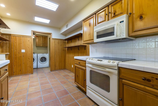 kitchen with tile countertops, washer and dryer, white appliances, and light tile patterned floors