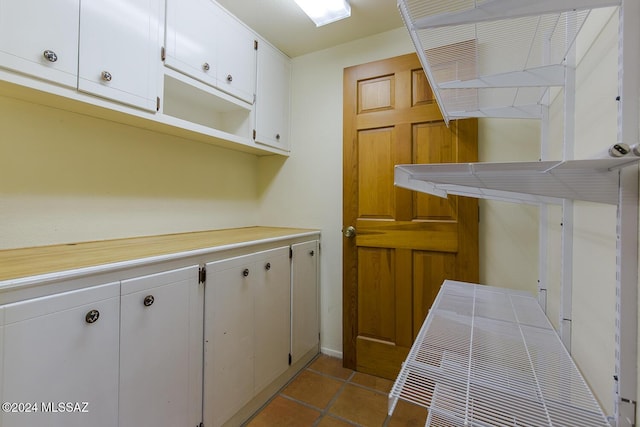 kitchen with white cabinetry and light tile patterned flooring