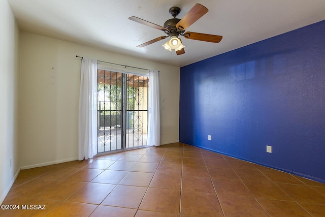 tiled empty room featuring ceiling fan