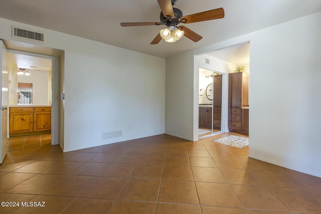 spare room featuring tile patterned floors and ceiling fan