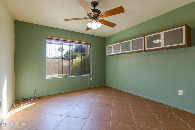 empty room featuring tile patterned flooring and ceiling fan