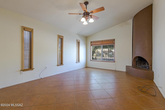 unfurnished living room with light tile patterned floors, a large fireplace, ceiling fan, and lofted ceiling