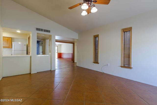 tiled empty room with ceiling fan and lofted ceiling