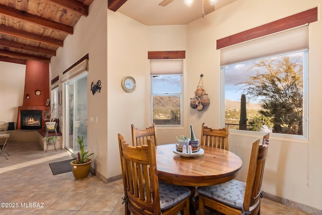 dining space featuring light tile patterned flooring, lofted ceiling with beams, ceiling fan, and wood ceiling