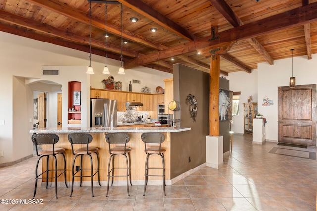 kitchen with beam ceiling, light stone countertops, stainless steel appliances, kitchen peninsula, and wood ceiling