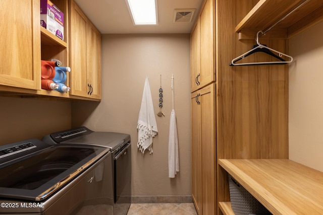 laundry room with cabinets, separate washer and dryer, and light tile patterned floors