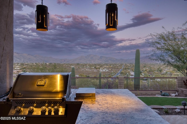 patio terrace at dusk with a mountain view and a grill