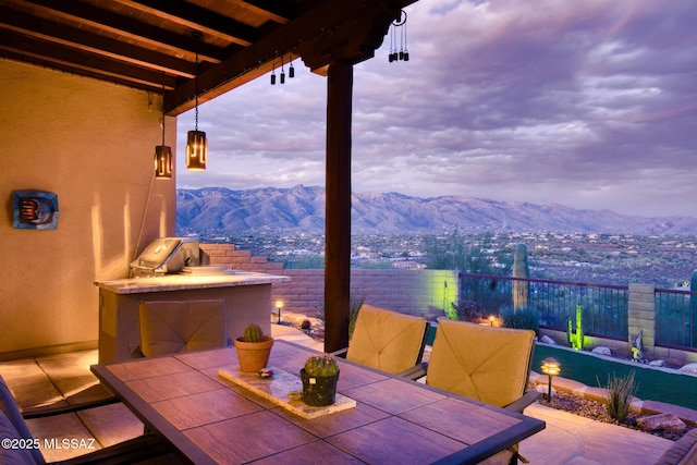 patio terrace at dusk featuring a mountain view