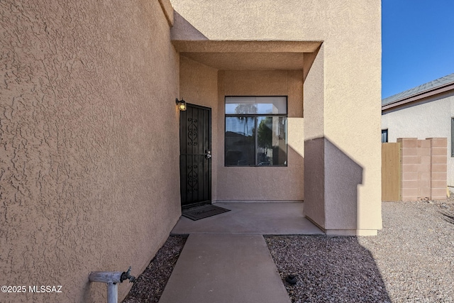 view of exterior entry with a patio