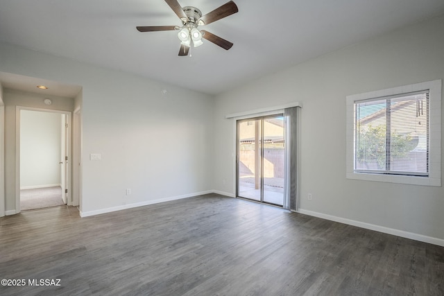 spare room featuring plenty of natural light, dark hardwood / wood-style floors, vaulted ceiling, and ceiling fan