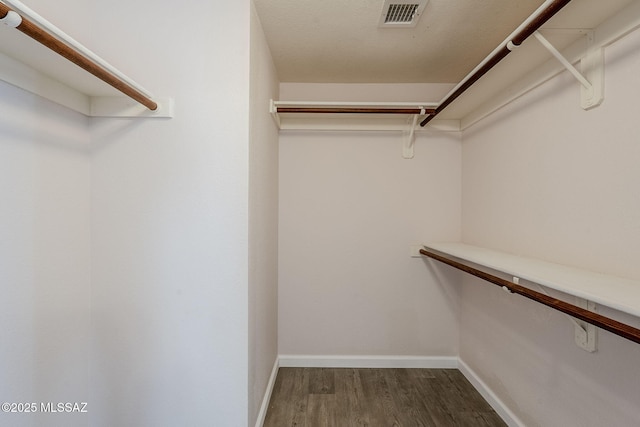 walk in closet featuring dark wood-type flooring