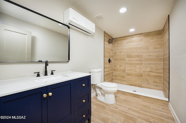 bathroom with a wall mounted air conditioner, vanity, toilet, and tiled shower