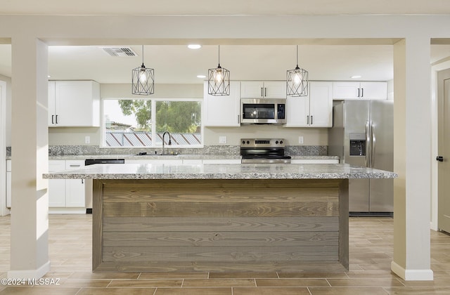 kitchen with a center island, white cabinetry, sink, and appliances with stainless steel finishes