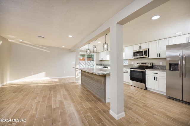 kitchen featuring white cabinetry, stainless steel appliances, and light stone counters