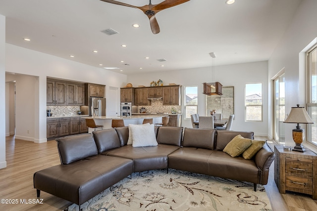 living room with ceiling fan and light wood-type flooring