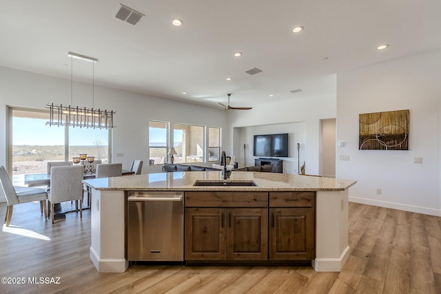 kitchen featuring dishwasher, decorative light fixtures, an island with sink, sink, and ceiling fan