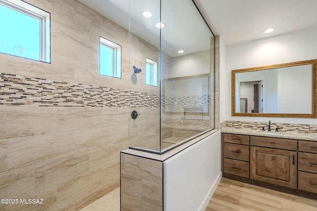 bathroom featuring vanity, hardwood / wood-style flooring, and tiled shower