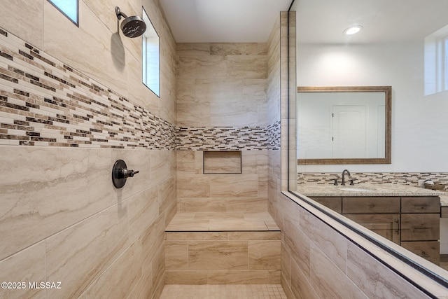 bathroom with a tile shower and sink