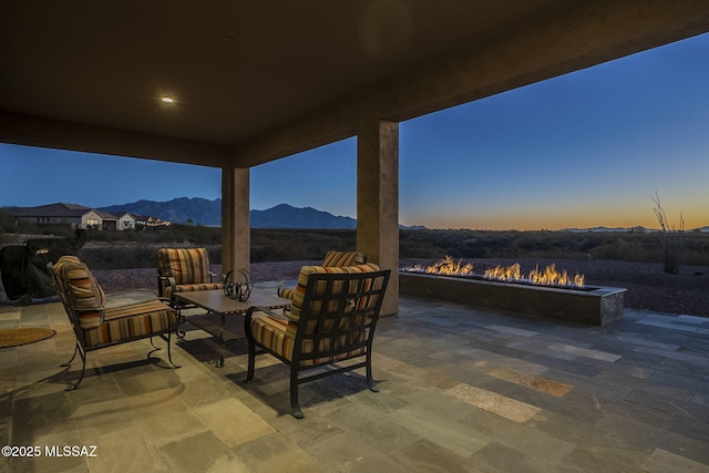 patio terrace at dusk with a mountain view and a fire pit