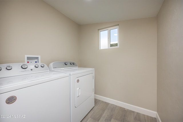 clothes washing area with light wood-type flooring and independent washer and dryer