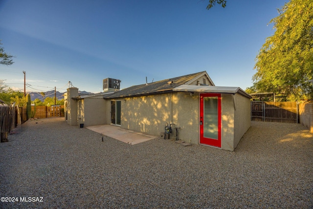 rear view of property with central AC unit and a patio area