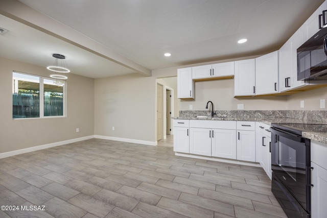 kitchen featuring pendant lighting, white cabinets, black appliances, sink, and light stone counters